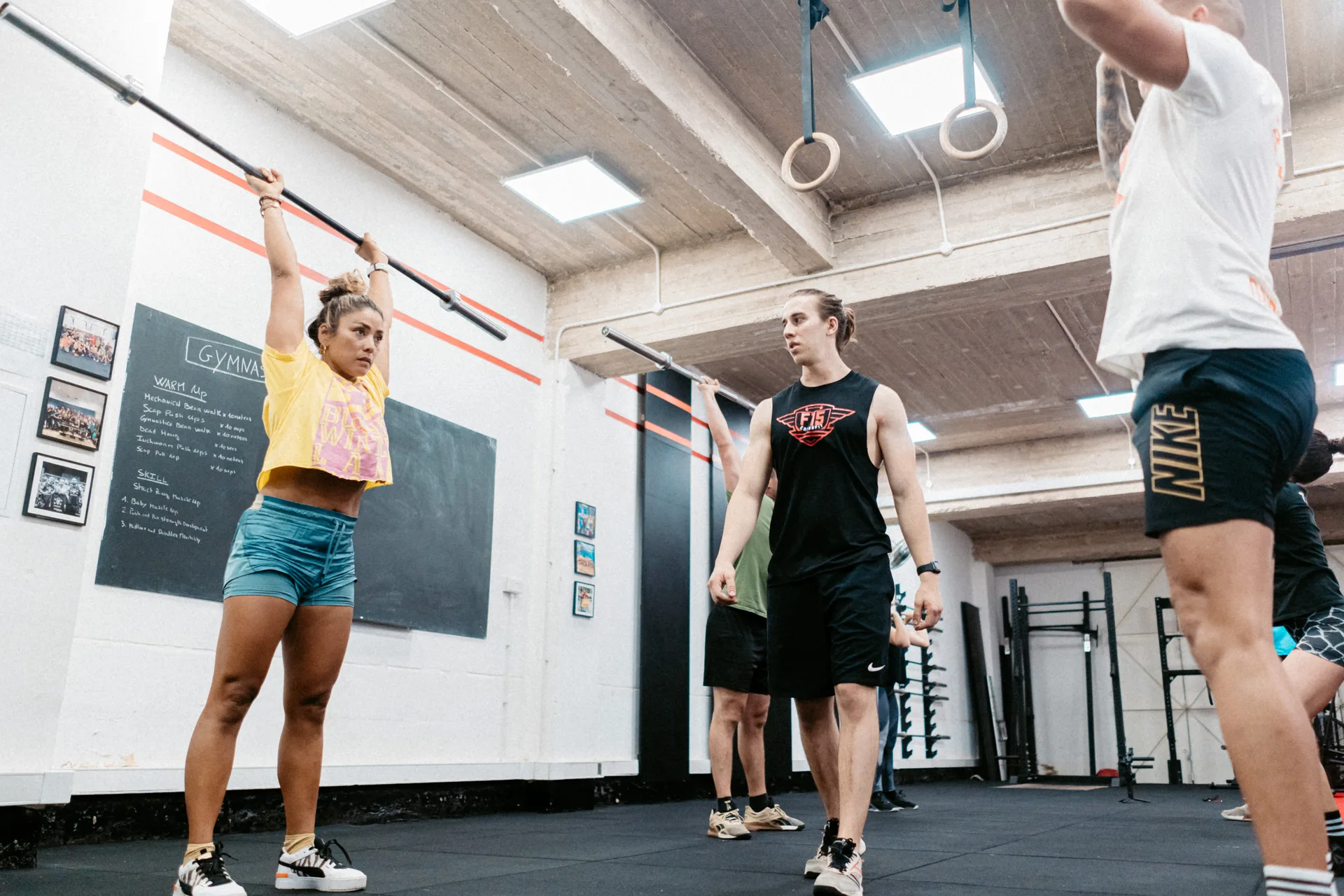 Coach guiding member through barbell warm-up in gymnastics class at F15 Training CENTR Malta
